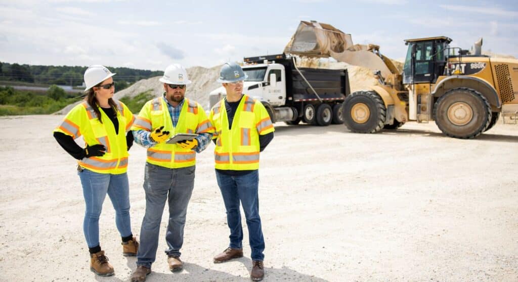 3 Reeve's construction workers standing at a worksite.